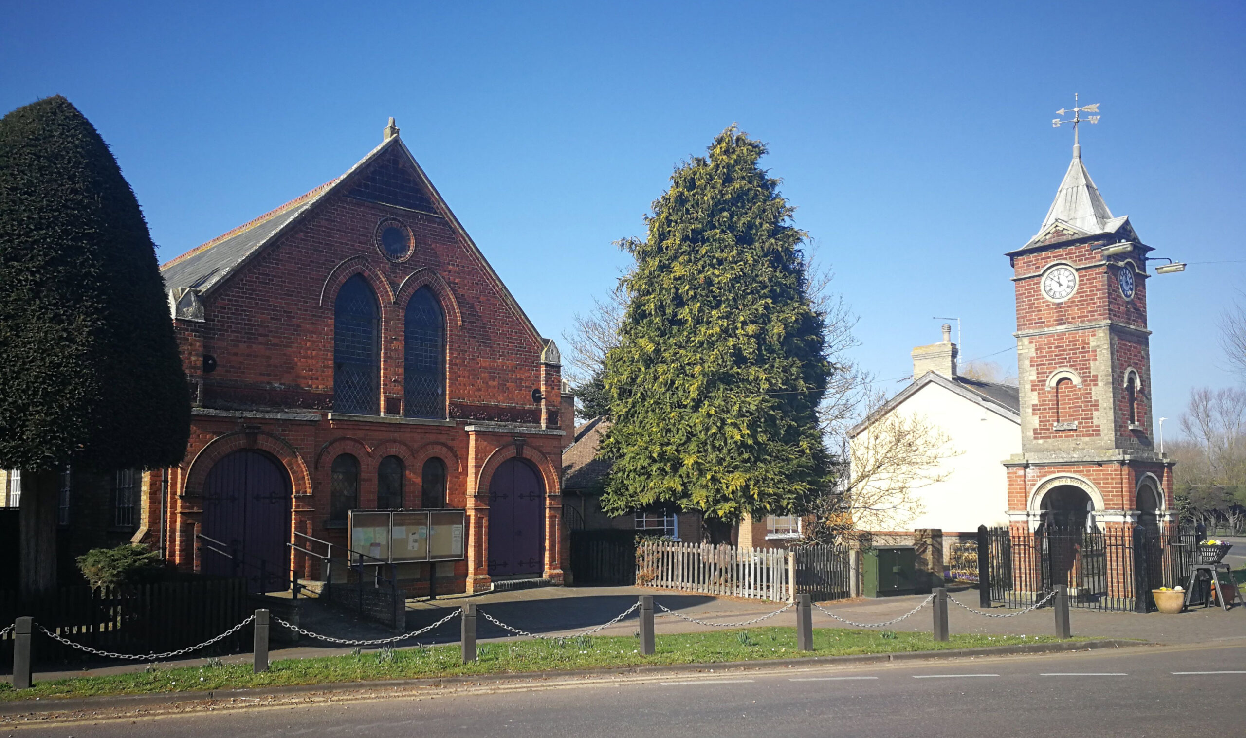 A view of the clock tower and hall on a sunny day in Doddington