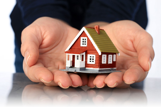 Hands and small house. Real estate or insurance concept.